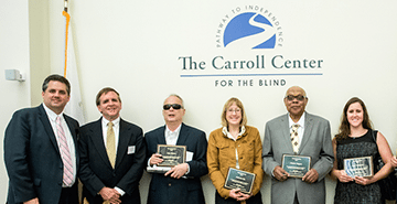 Carroll Center for the Blind President Gregory Donnelly stands beside Former MCB Commissioner Paul Saner and four Carroll Society Award winners holding their awards.