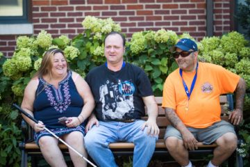 Three clients enjoying each other's company on the Carroll Center for the Blind campus.