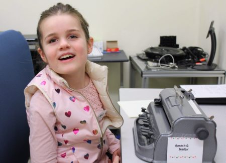 With a perkins brailler in front of her, top scorer in the “Freshman” category, Hannah Gevers, smiles.