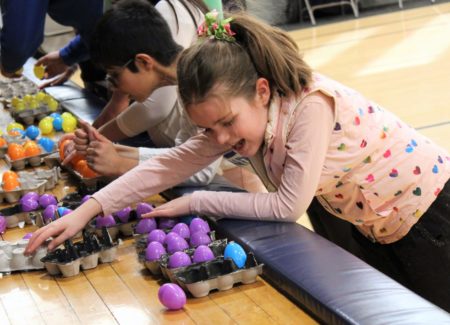 Freshman category winner Hannah works with her fellow participants to solves a braille puzzle made out of egg cartons.