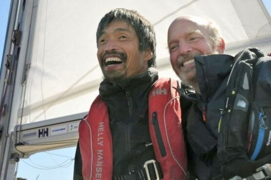 Blind sailor, Mitsuhiro Iwamoto (left), celebrates his 2-month journey of crossing the Pacific ocean with his navigator, Doug Smith (right) on the bow of their sail boat.