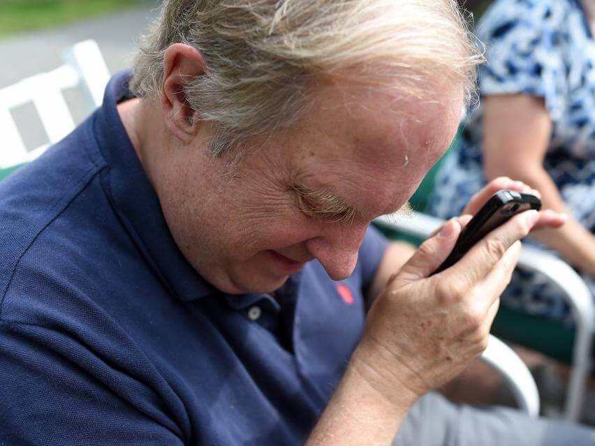 Assistive Technology Instructor, David Kingsbury, pictured using VoiceOver on his phone, recently appeared on the Eyes On Success podcast.