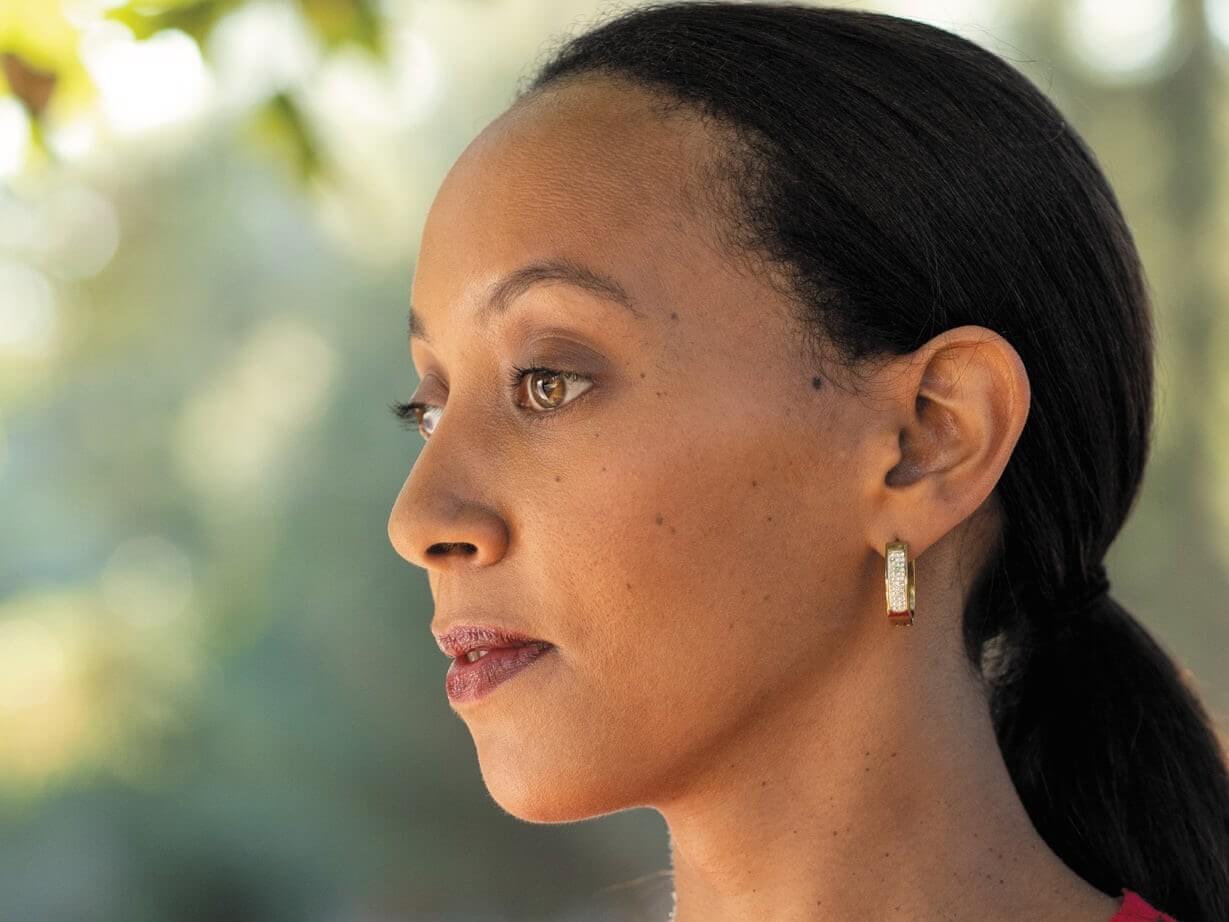 A side-profile close-up of deafblind lawyer and activist, Haben Girma.