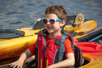 While floating back to the dock, a student in the Carroll Kids program smiles from his kayak.