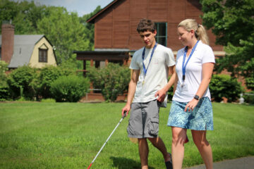 A Youth in transition student walks along the driveway at the carroll center during an orientation and mobility lesson.
