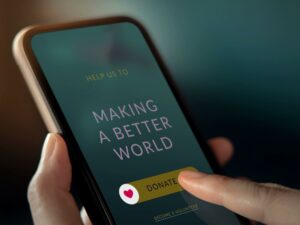 On a cellphone, a person presses a button that reads, donate.