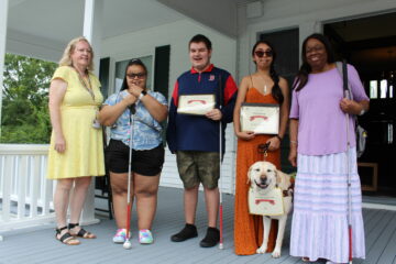 Real World Of Work instructors and students holding certificates at graduation