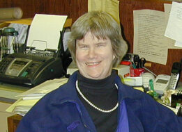 Smiling Michele Aldrich sitting at her desk