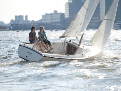 2 SailBlind sailors smiling and talking to each other on a boat