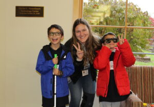 2 Cane Quest participants, who are twin brothers, with big happy smiles posing for a picture with their family after exchanging their coins for prizes