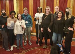 A group of Carroll Alumni smiling for a picture at the theatre after attending a musical