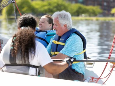 3 SailBlind sailors smiling on a boat